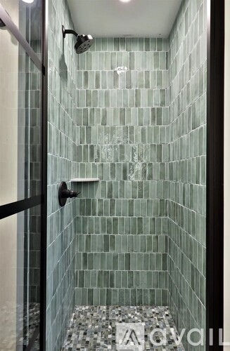 A shower with a glass door and a glass shower head.