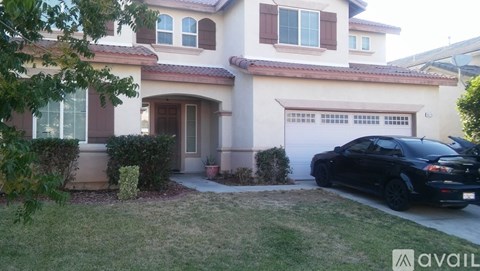 A black car is parked in front of a house.