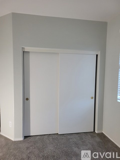 A white door is in a room with a carpeted floor.