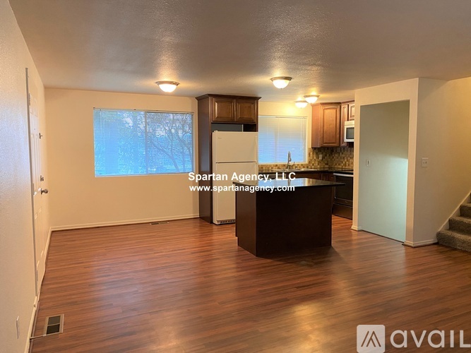 A spartan agency office with wood flooring and a reception desk.