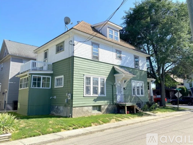 A two-story house with a green exterior and white trim.