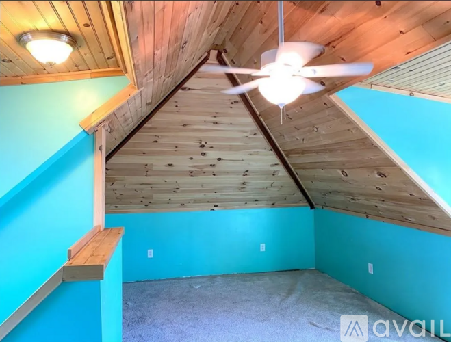 A room with a wooden ceiling and a fan.