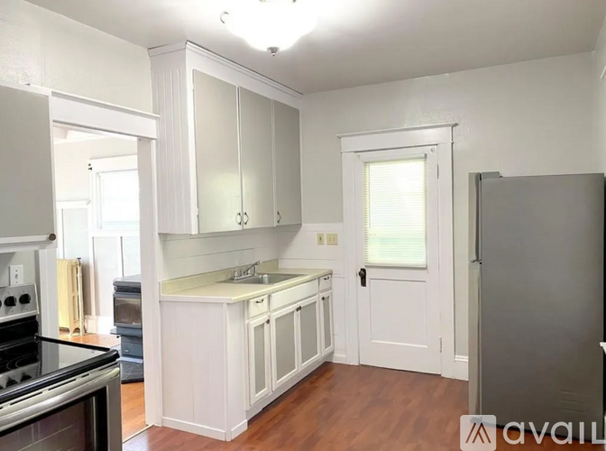 A kitchen with white cabinets and a black stove top oven.