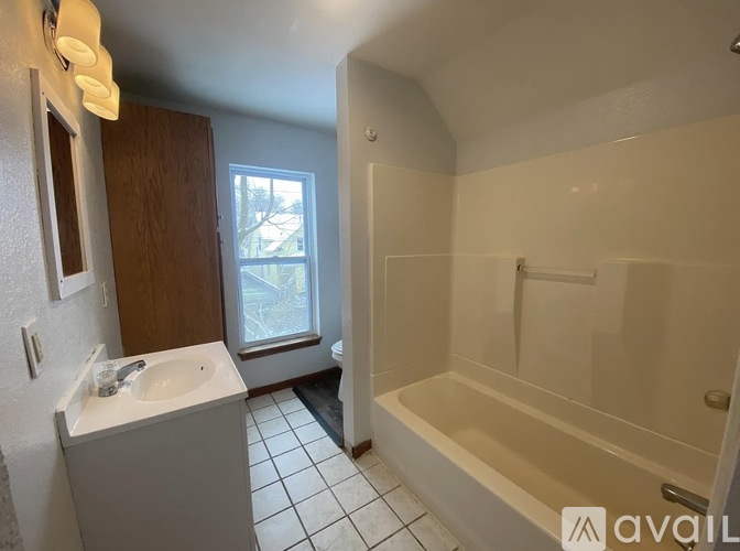 A bathroom with a white sink and bathtub.