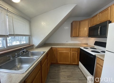 A kitchen with wooden cabinets and a white refrigerator.
