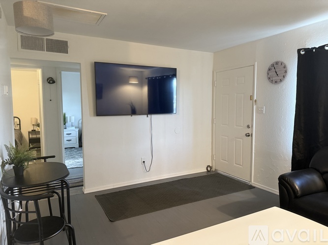 A living room with a flat screen TV mounted on the wall.