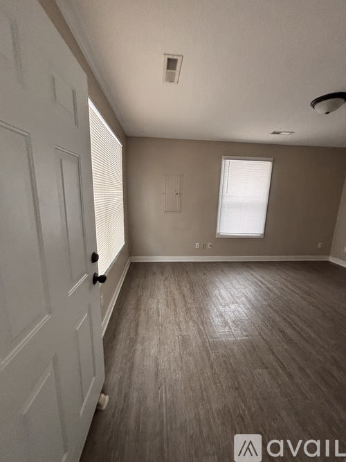A room with wooden flooring and a white door.