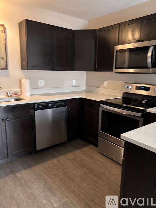 A kitchen with black cabinets and stainless steel appliances.