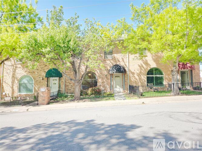 A building with a green awning and a tree in front of it.