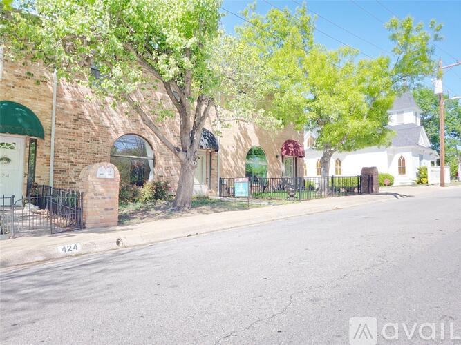 A street view with a church, trees, and a building with a sign that says "AVAIL".