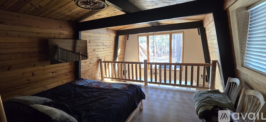A bedroom with a bed and a window with blinds.
