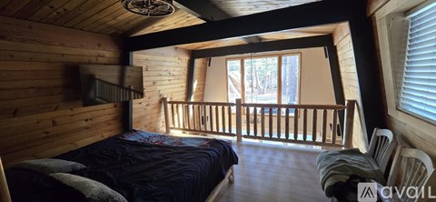 A bedroom with a bed and a window with blinds.