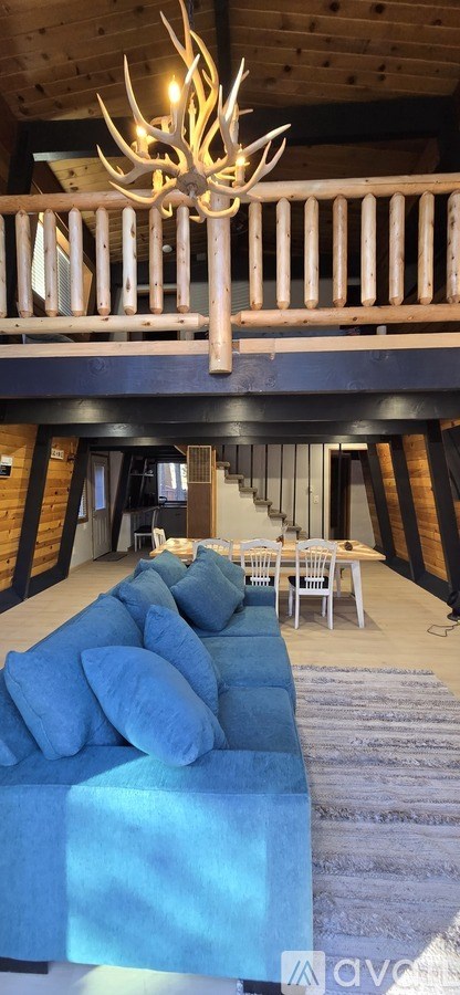 A living room with a blue couch and a wooden chandelier.