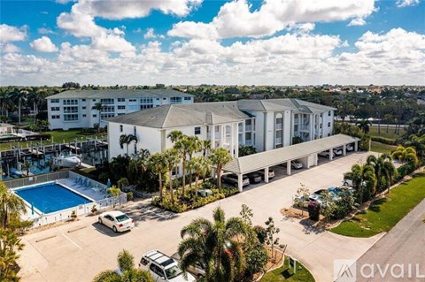 A large white building with a pool in front of it.
