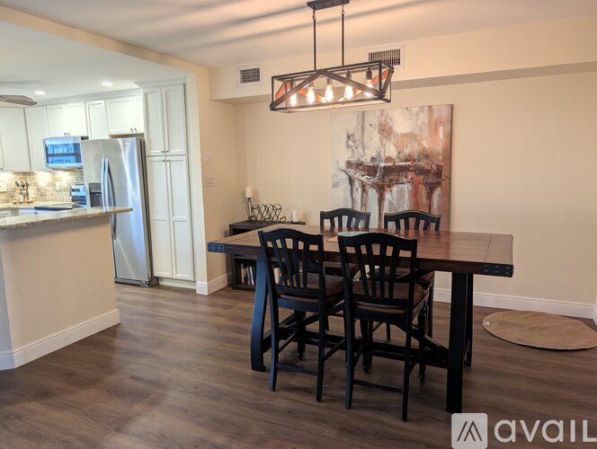 A kitchen with a dining table and chairs.