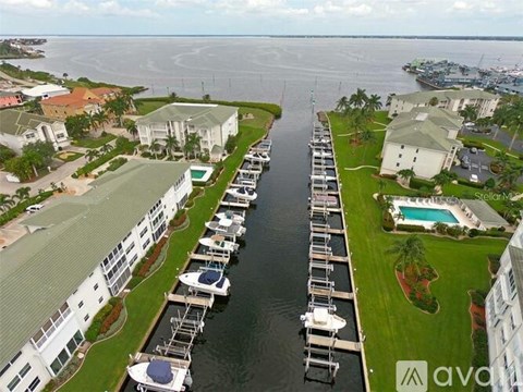 A marina with boats docked and buildings alongside a body of water.