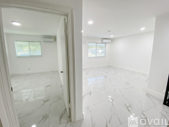 A spacious room with marble flooring and white walls.