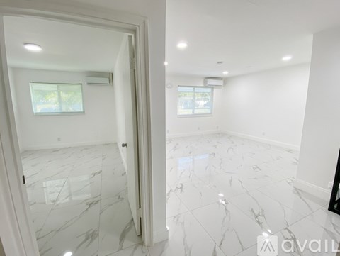 A spacious room with marble flooring and white walls.