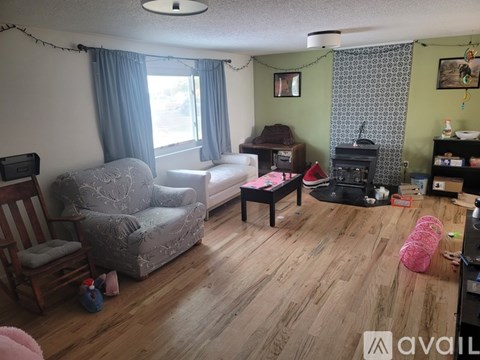 A living room with a grey sofa and a wooden floor.