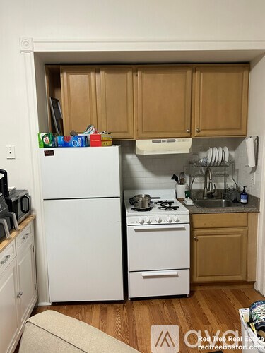 A small kitchen with a white refrigerator and a white stove top oven.