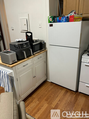 A small kitchen with a white fridge and a microwave on the counter.