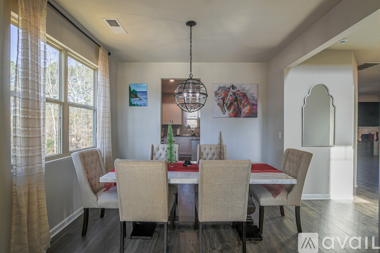 A dining room with a table and chairs.