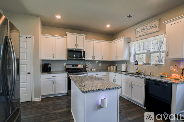 A kitchen with granite countertops and white cabinets.