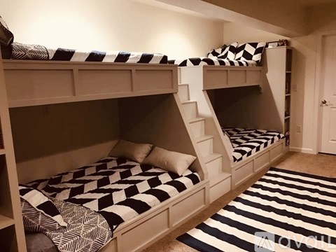 A room with two bunk beds and striped carpet.