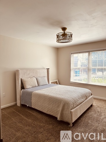 A bedroom with a large bed and a window overlooking a cityscape.