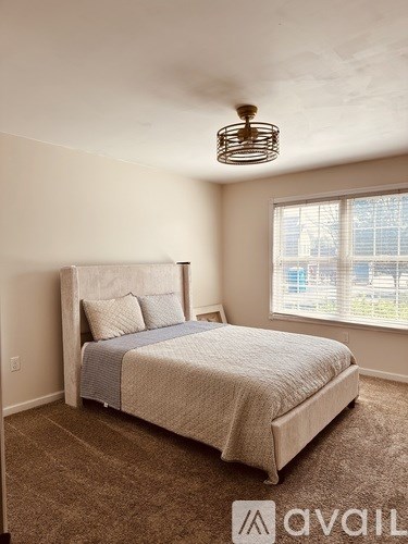 A bedroom with a large bed and a window overlooking a cityscape.