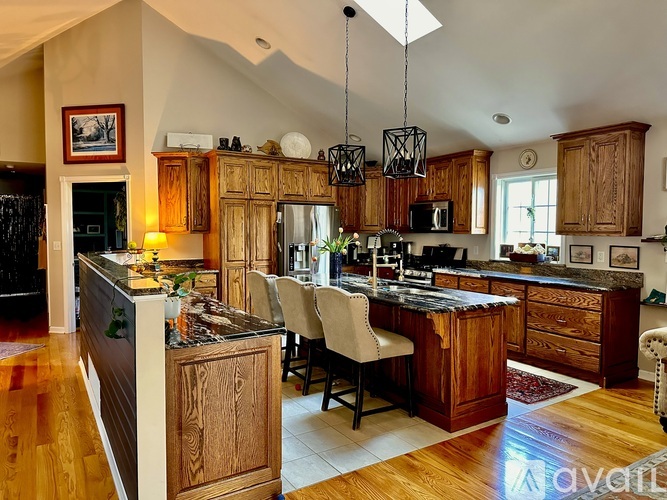 A kitchen with wooden cabinets and a black island.