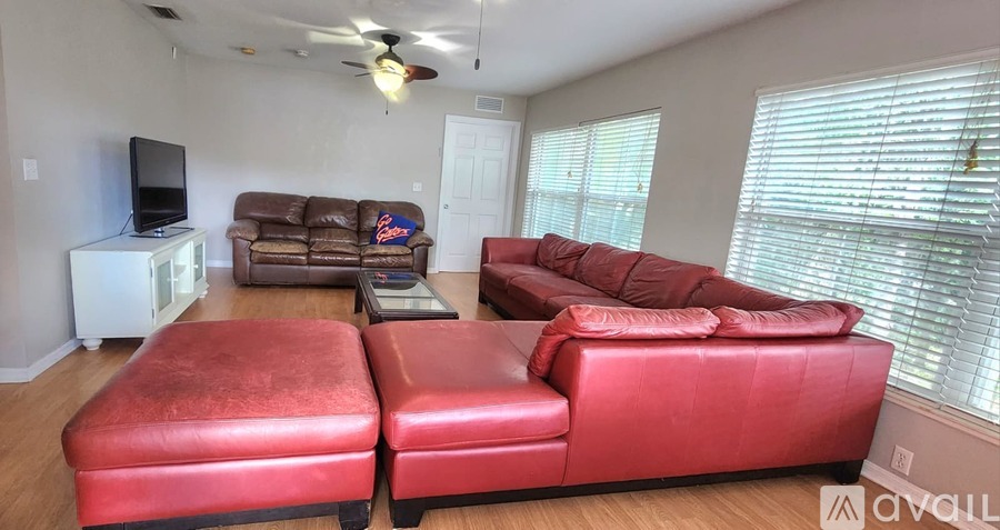 A living room with red couches and a television.