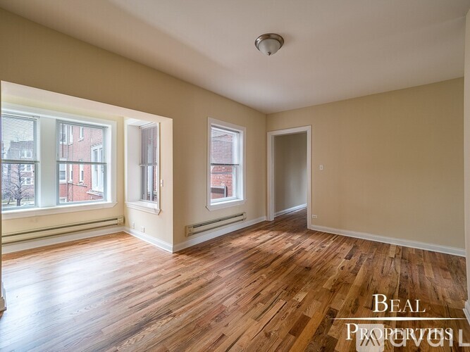 A room with wooden floors and a large window.