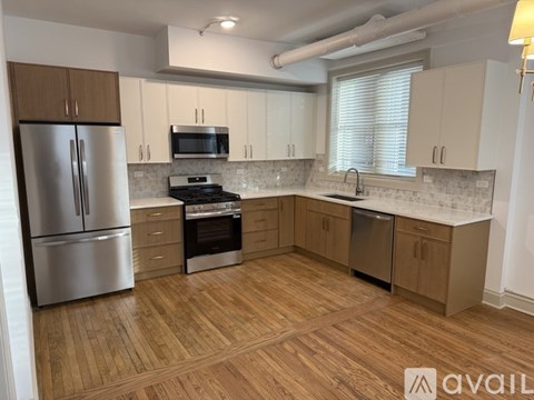 A kitchen with wooden floors and stainless steel appliances.