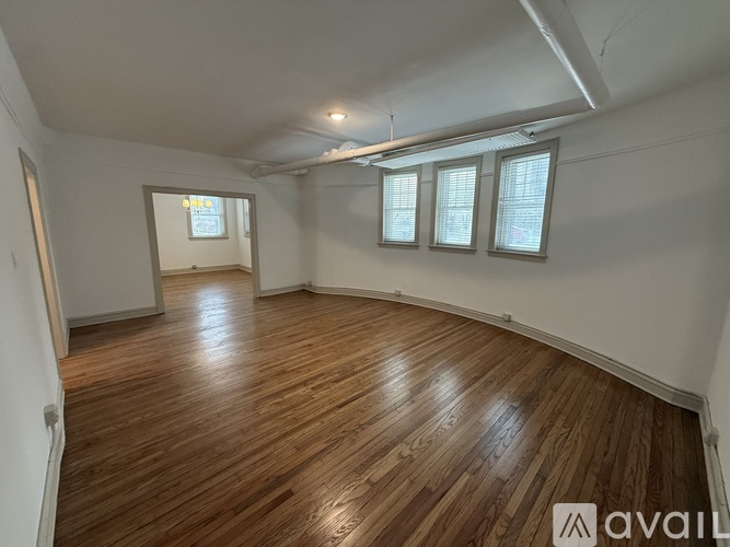 A room with wooden flooring and white walls.