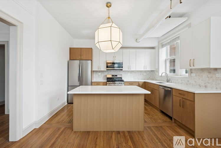 A kitchen with wooden floors and stainless steel appliances.