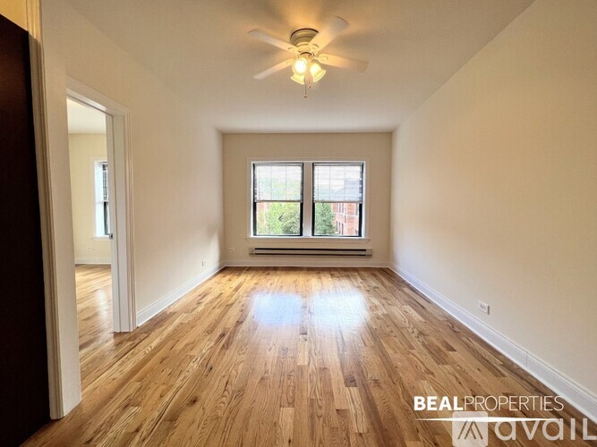 A room with wooden floors and a ceiling fan.