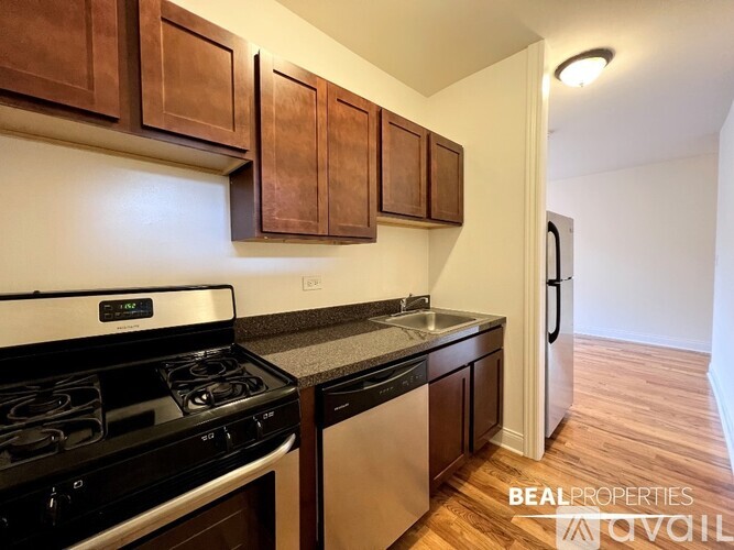 A kitchen with dark wood cabinets and a black stove top oven.