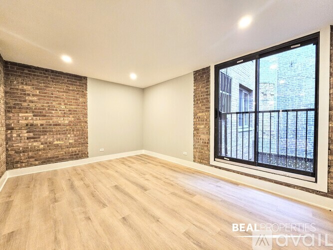 A room with a brick wall and a window overlooking a balcony.