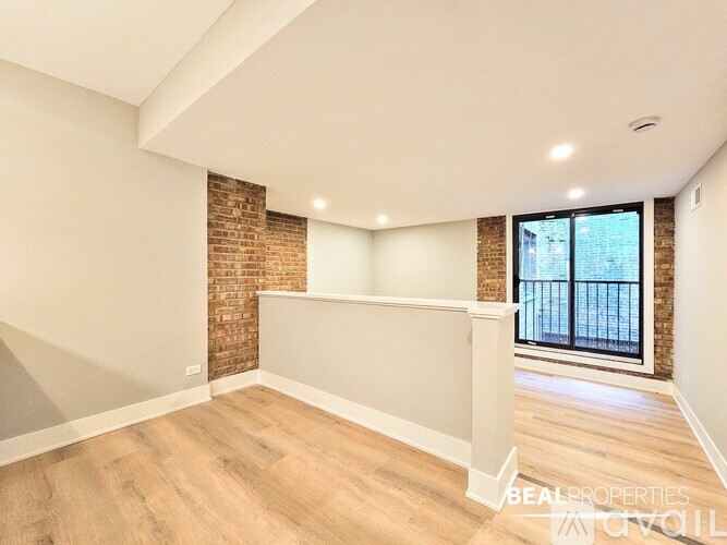 A room with a brick wall and wooden flooring.