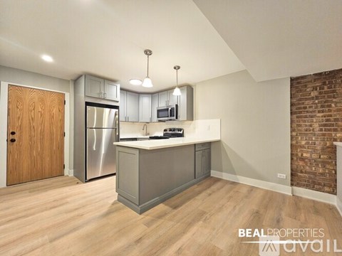 A kitchen with a refrigerator, microwave, and oven.