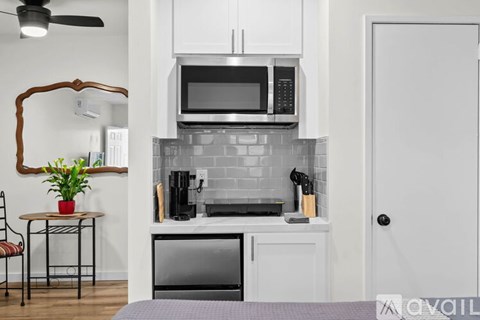 A kitchen with a microwave and oven built into the cabinetry.