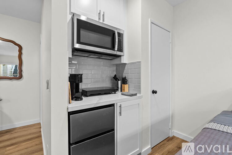 A kitchen with a microwave and oven built into the cabinetry.