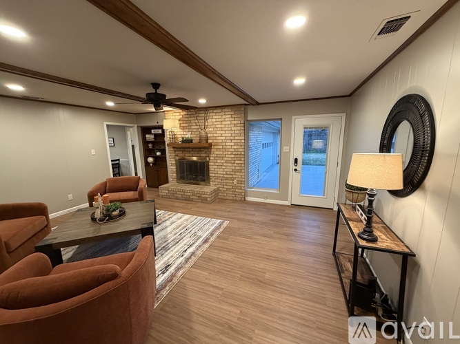 A living room with a fireplace and a ceiling fan.