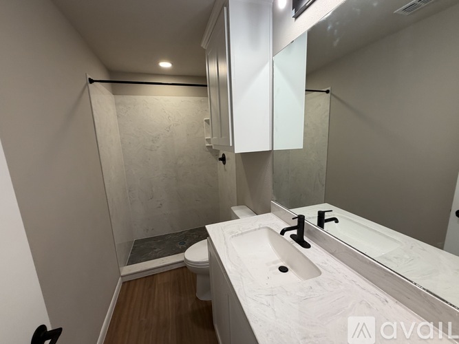 A bathroom with a toilet, sink, and shower.
