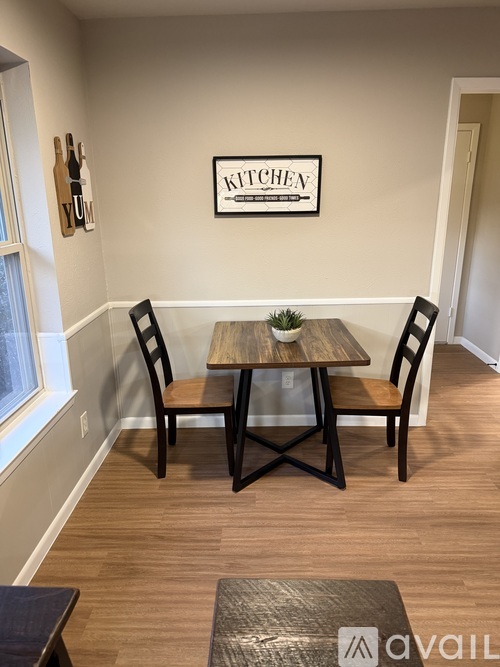 A kitchen area with a table and chairs.