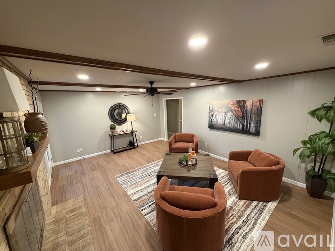 A living room with a ceiling fan and a painting on the wall.