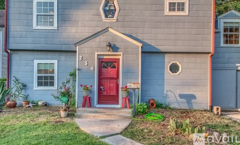 A blue house with a red door and a small porch.