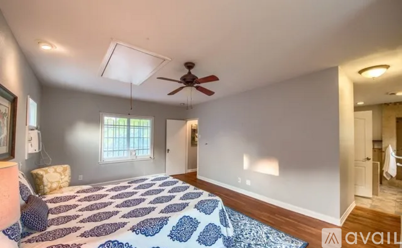 A bedroom with a bed and a ceiling fan.