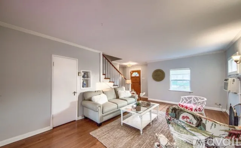 A living room with a white couch and a coffee table.